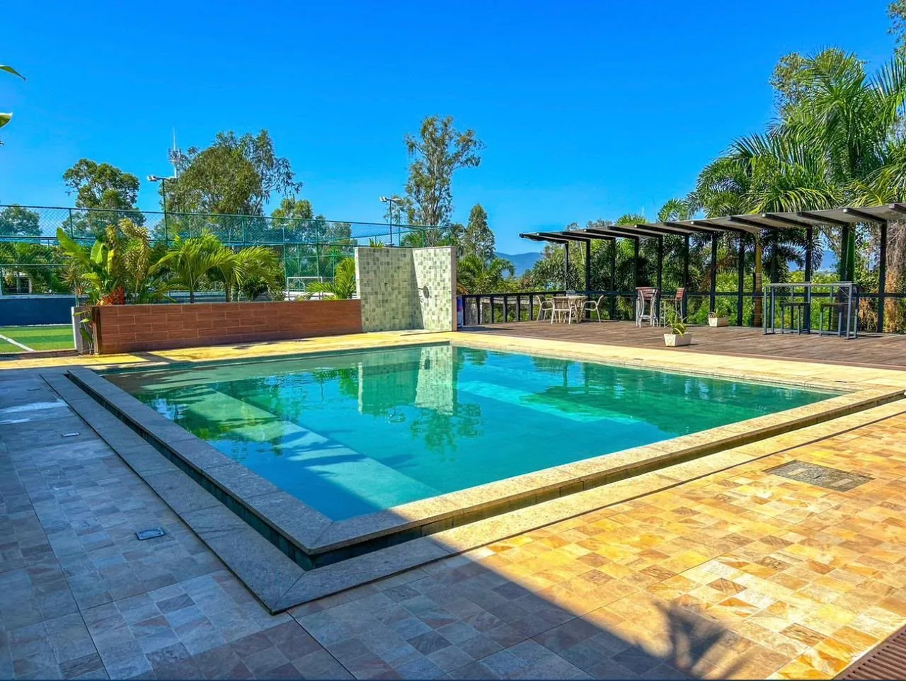 Piscina do Lima’s Village, cercada por área de convivência e vegetação